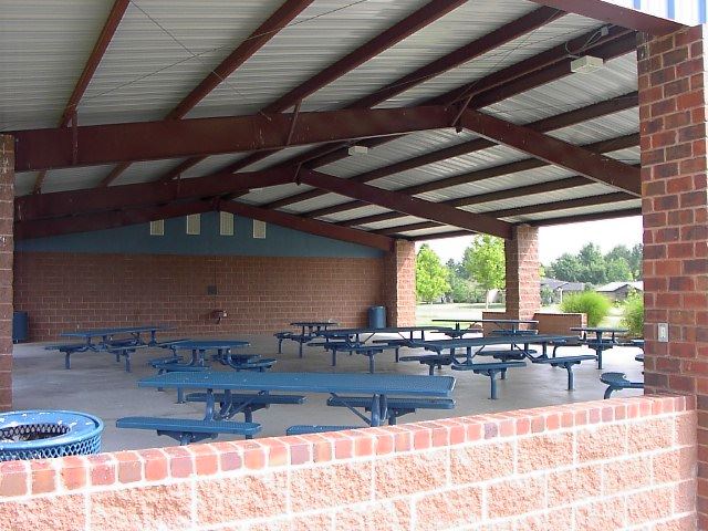 A shaded picnic area with multiple tables and benches